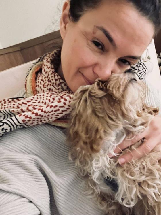 Myriam faisant un câlin à un petit chien à poil bouclé
