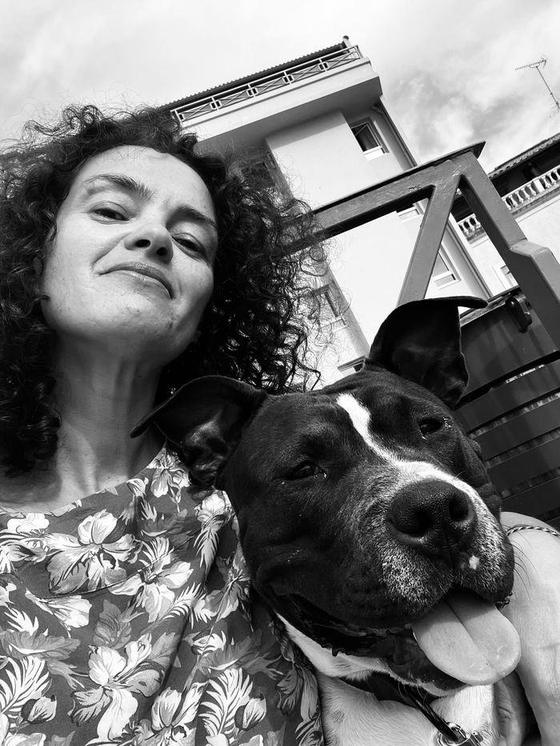 Portrait en noir et blanc de Myriam avec un chien de type amstaff